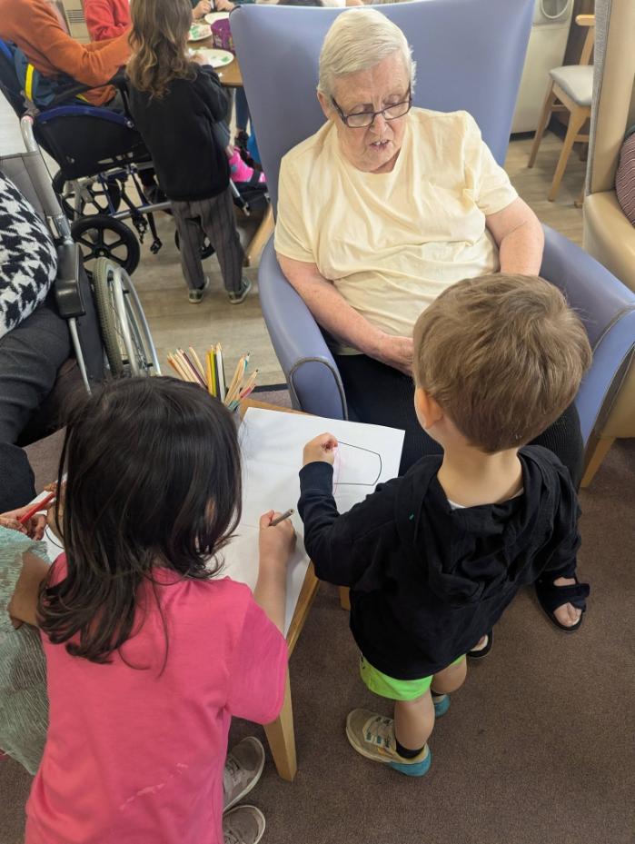 pre school children with resident talking and doing arts and cratfs