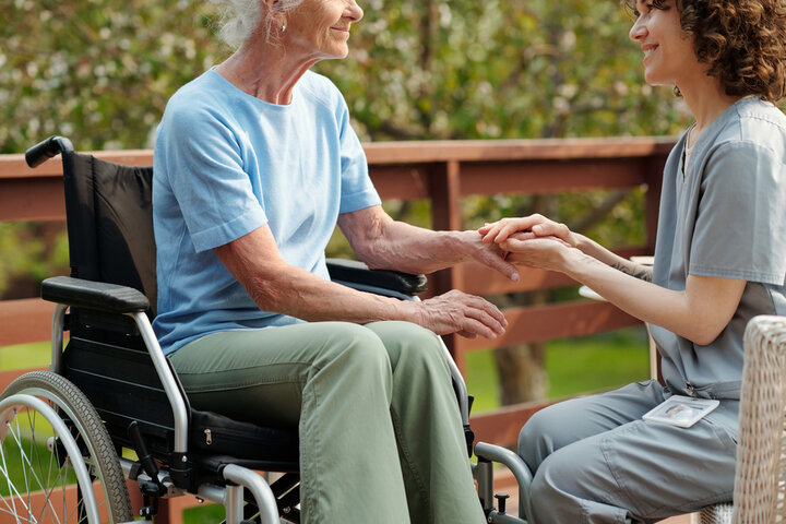 carer and resident outside in a wheelchair