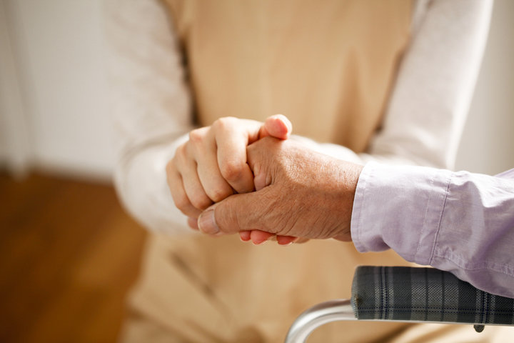 person holding someones hand in a wheelchair