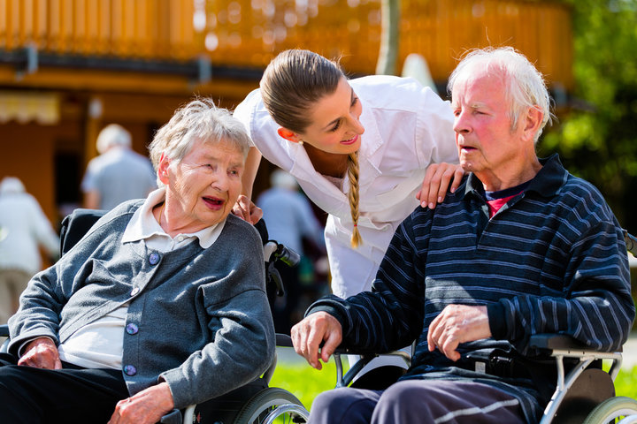 carer-with-residents-in-wheelchairs-outside