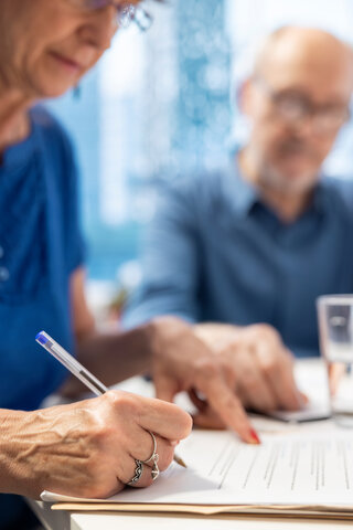 older couple looking at care costing documents together and writing things down