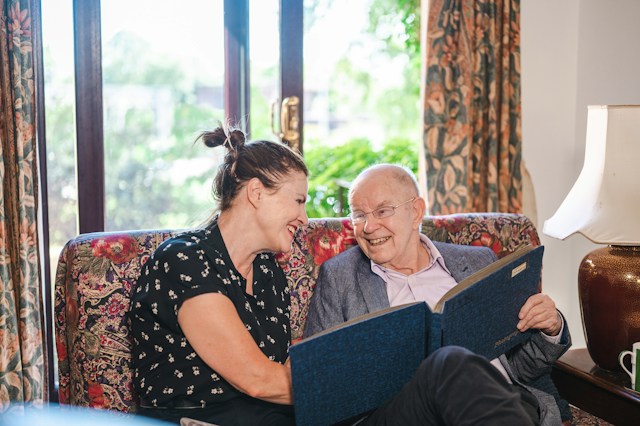 resident looking through family pictures with daughter